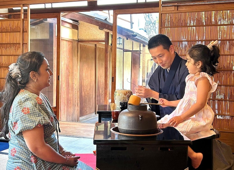 Una ceremonia tradicional del té japonesa con participantes sentados alrededor de una mesa baja. 1