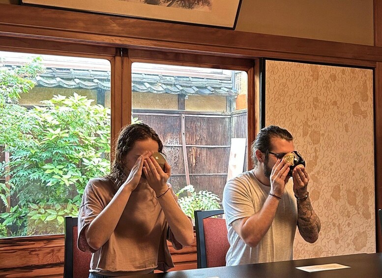 Dos personas sentadas en una mesa adentro, con vista a un jardín. 5