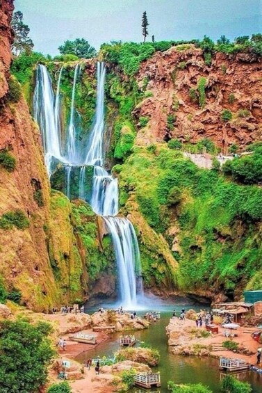 A multi-tiered waterfall surrounded by lush greenery and rocky cliffs. 5