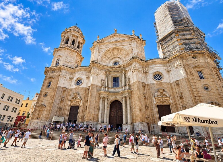 A historic church with two bell towers and a large central dome, surrounded by a crowd of tourists. 3