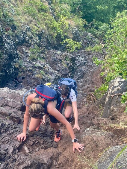 Two hikers navigating a rocky terrain with backpacks. 3