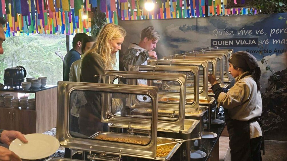 A buffet line with food service staff and patrons. 3