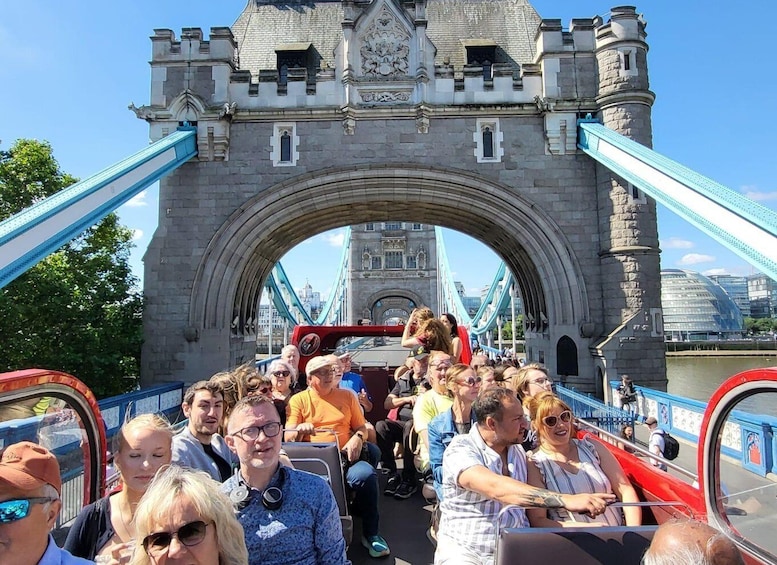 A group of people on a boat ride across a bridge with a large arch structure. 5