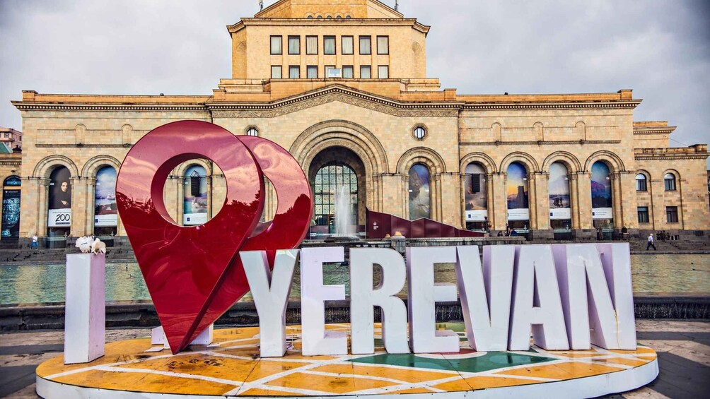 A large heart-shaped sculpture with the text "I ❤️ Yerevan" in front of a historic building. 1