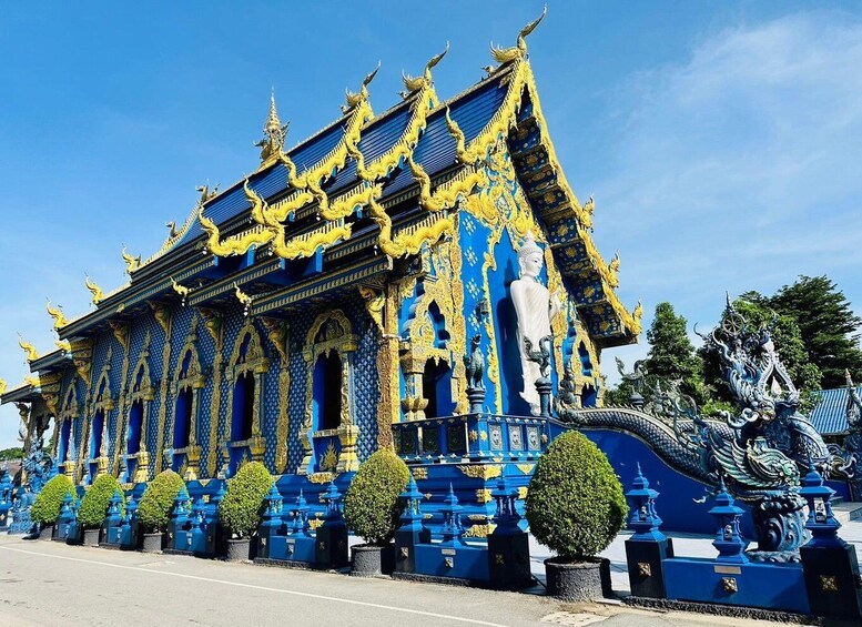 A temple with blue and gold decorations, a large Buddha statue, and a dragon sculpture. 3
