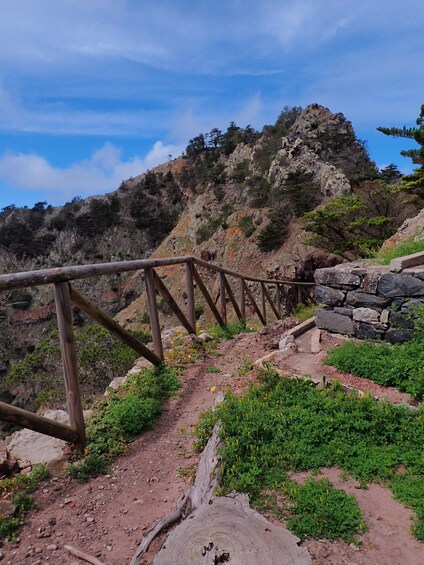 A wooden bridge over a rocky trail with a mountain in the background. 3