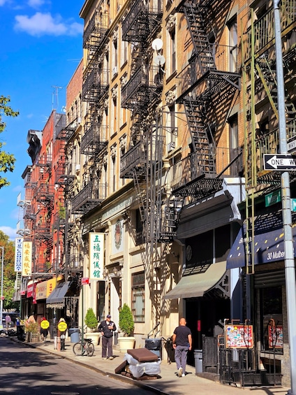 A street with buildings, fire escapes, and signs. 2