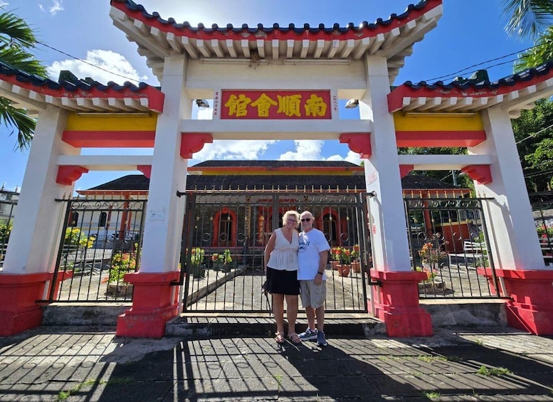 A traditional gate with Chinese characters, a clear sky, and a paved entrance area. 3