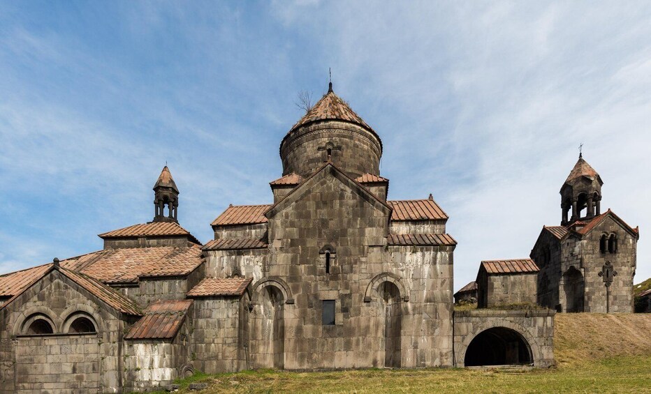 A historic stone church with multiple domes and bell towers. 5