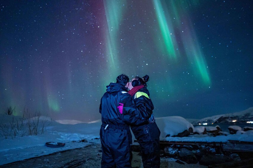 Two people embracing under the aurora borealis. 3