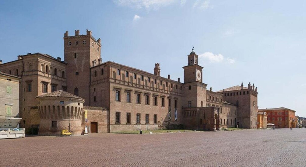 A historic building with a clock tower and a courtyard. 5