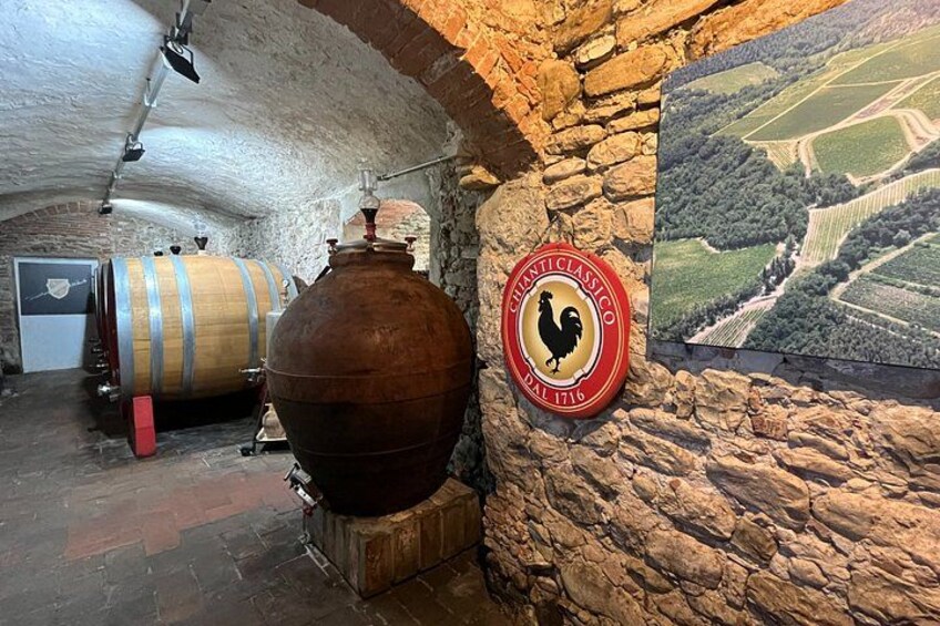 A cellar with stone walls, wooden barrels, and a large copper vessel. 5