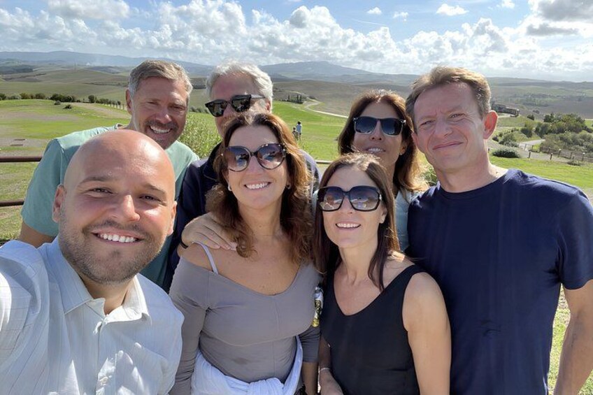A group of people outdoors with a hilly landscape in the background. 3