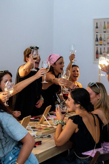 A group of people toasting with wine glasses at a table with various items on it. 3