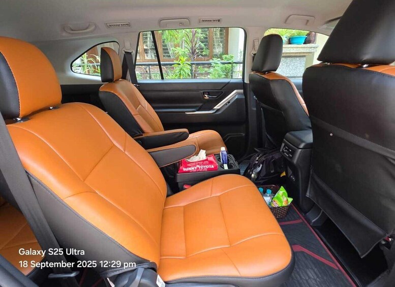 The interior of a Galaxy S25 Ultra car with orange leather seats and a center console. 4