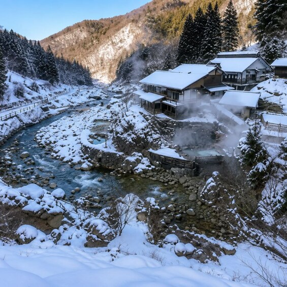 Un paysage enneigé avec une rivière, des bâtiments et des montagnes. 4
