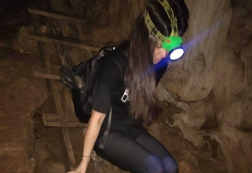 A person climbing a rocky surface with a backpack and a headlamp. 4