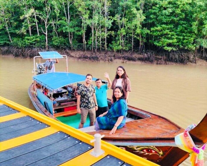 A group of people on a boat with a blue canopy, surrounded by a river and dense greenery. 2