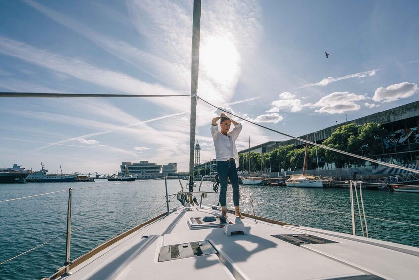 A person standing on a sailboat's deck, adjusting the sail. 5