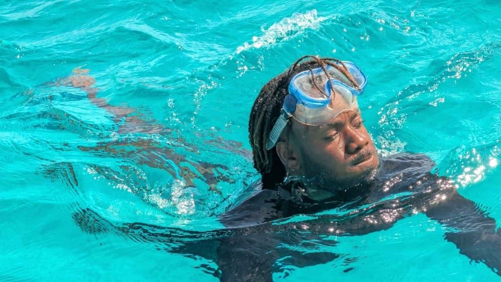 A person swimming in clear blue water. 5