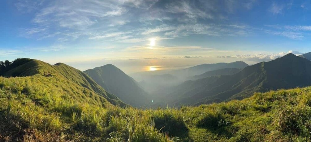 A valley with a sunrise, rolling hills, and a clear sky. 3