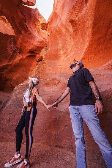 A couple holding hands in a red rock canyon. 1