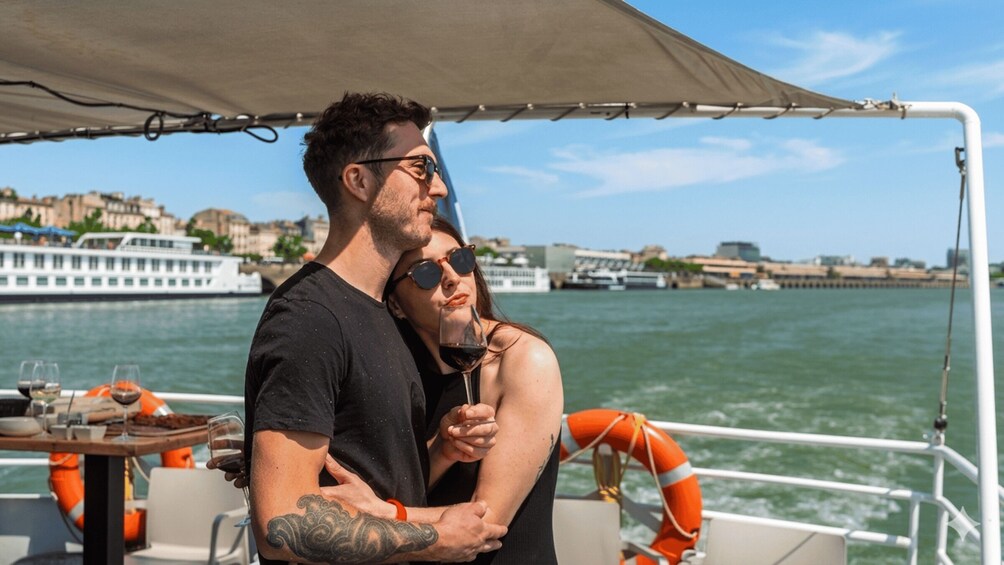 A couple on a boat with a cityscape in the background. 1