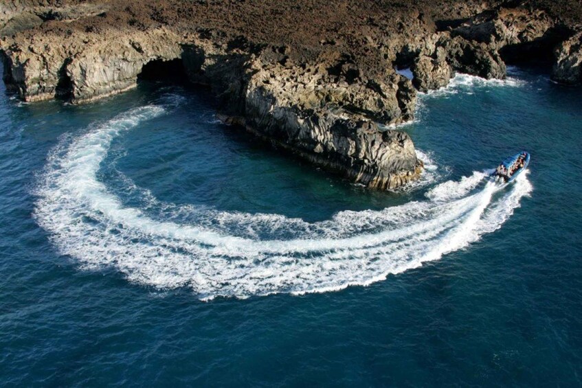 A person wakeboarding on a river, surrounded by rocky cliffs. 1