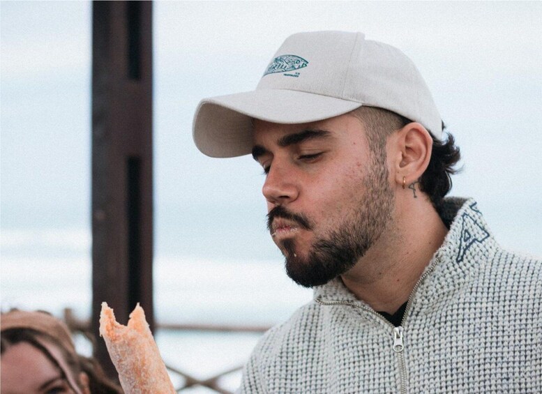 A person wearing a white cap and a patterned jacket. 3