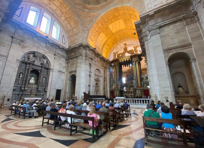 A church interior with a congregation seated on pews facing the altar. 4