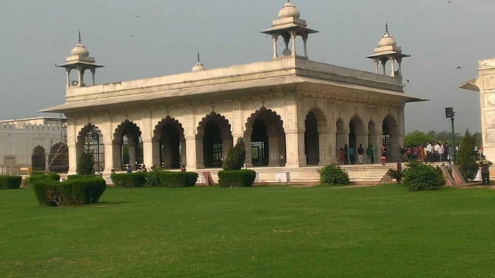 A large, ornate building with multiple domes and arches, surrounded by well-maintained lawns and pathways. 1