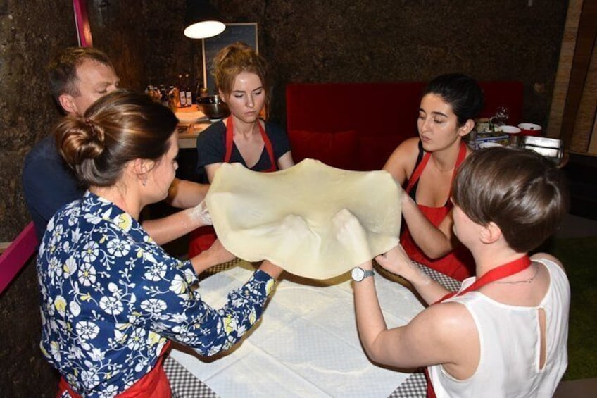A group of people engaged in a cooking activity around a table. 2