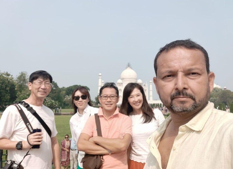 A group of people standing in front of the Taj Mahal. 1