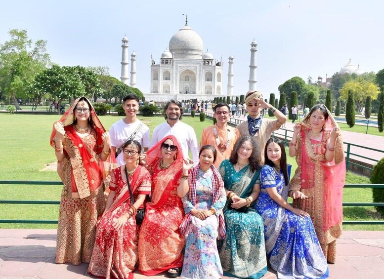 A group of people in traditional attire posing in front of the Taj Mahal. 5