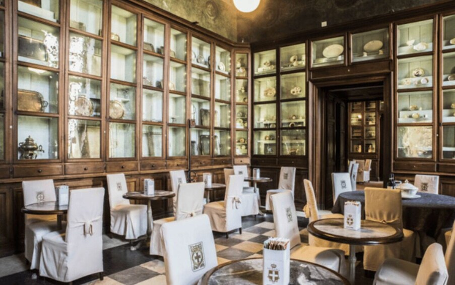 A restaurant with wooden cabinets displaying dishes and a checkered floor. 3