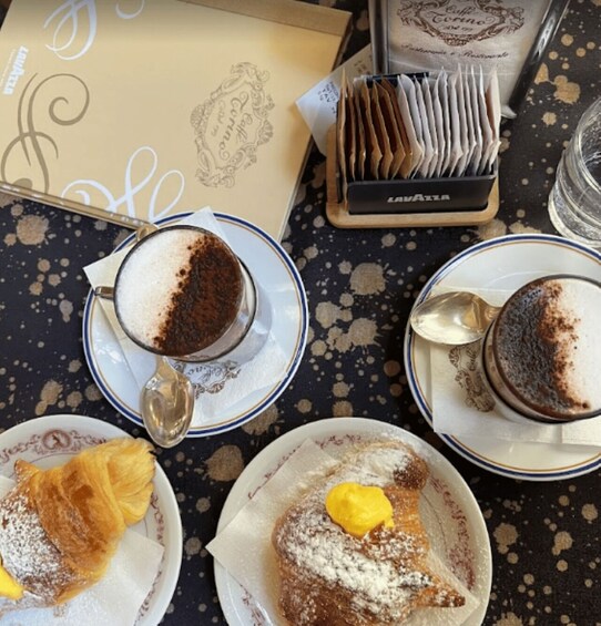 A table with coffee cups, pastries, and a menu. 2