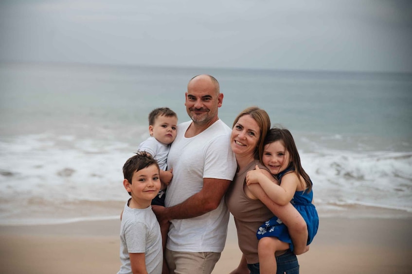 A family on a beach with waves in the background. 1