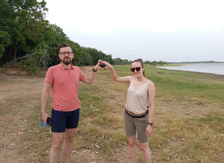 Zwei Personen draußen in der Nähe von Wasser, eine hält eine Kamera. 2