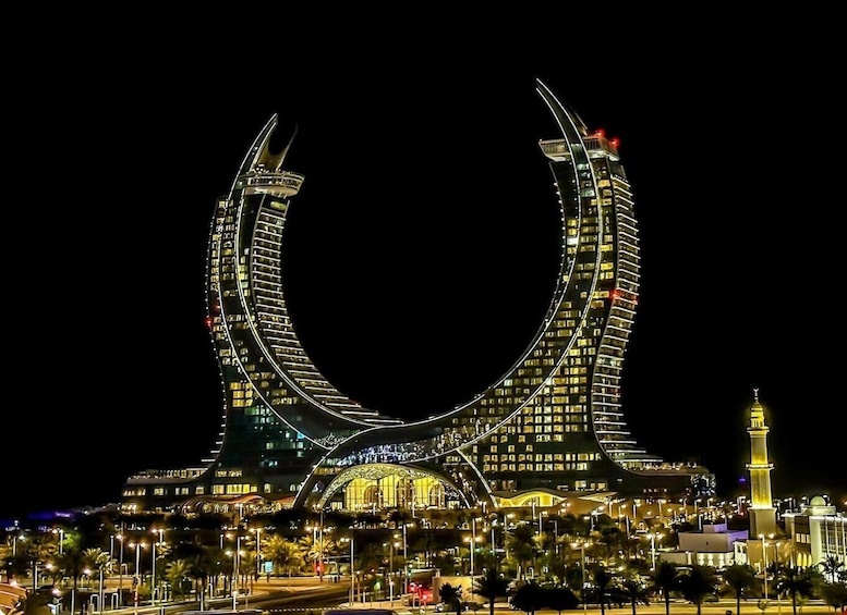 A large, illuminated arch structure at night. 2
