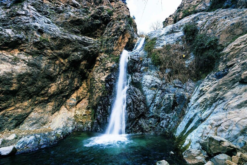 A waterfall cascading down a rocky cliff into a pool of water. 5