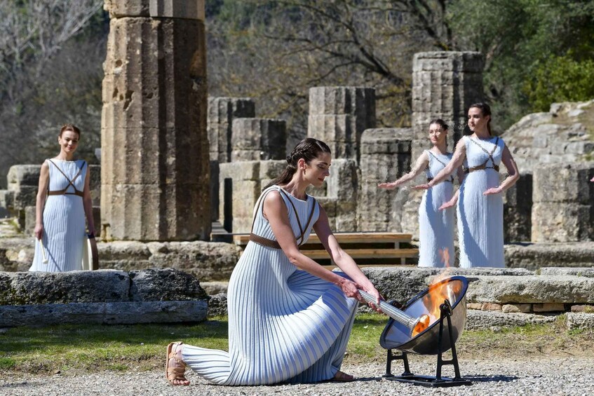 A person cooking outdoors near ancient ruins. 2