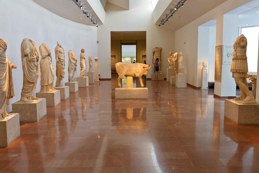 A museum with marble statues on pedestals arranged in a row. 4