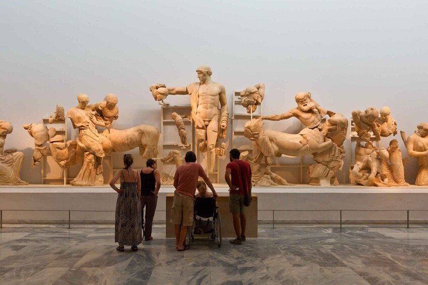 A marble sculpture display in a museum with visitors observing. 1