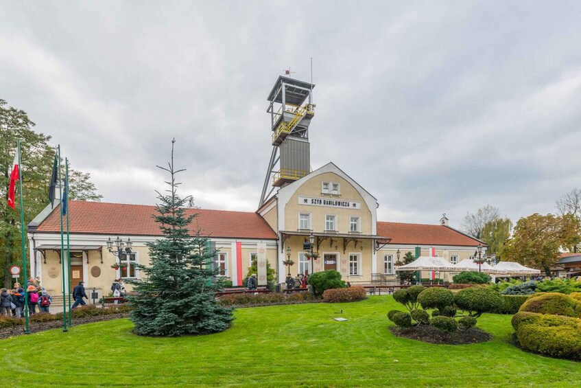 A building with a sign reading "Sztad Barilowicza" and a tall structure with a yellow staircase. 2