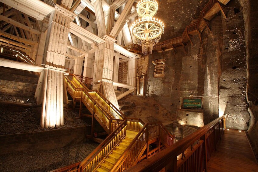 A historic stone building with wooden staircases and a chandelier. 4