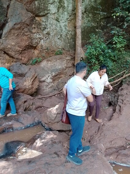 Three people near a rocky terrain with a stream. 3