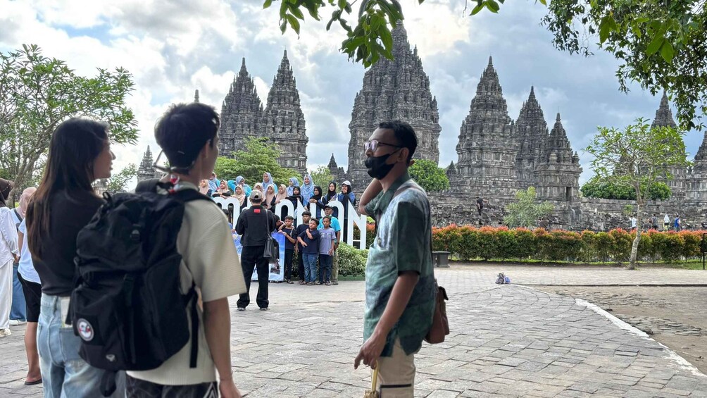 A group of people standing in front of a temple with multiple spires. 3