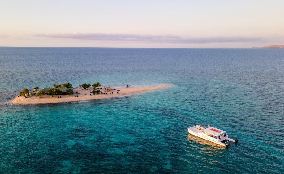 A small island with a boat docked near it. 1