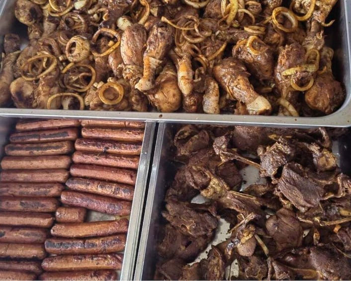 A variety of cooked meats, including sausages and roasted chicken, displayed in trays. 3
