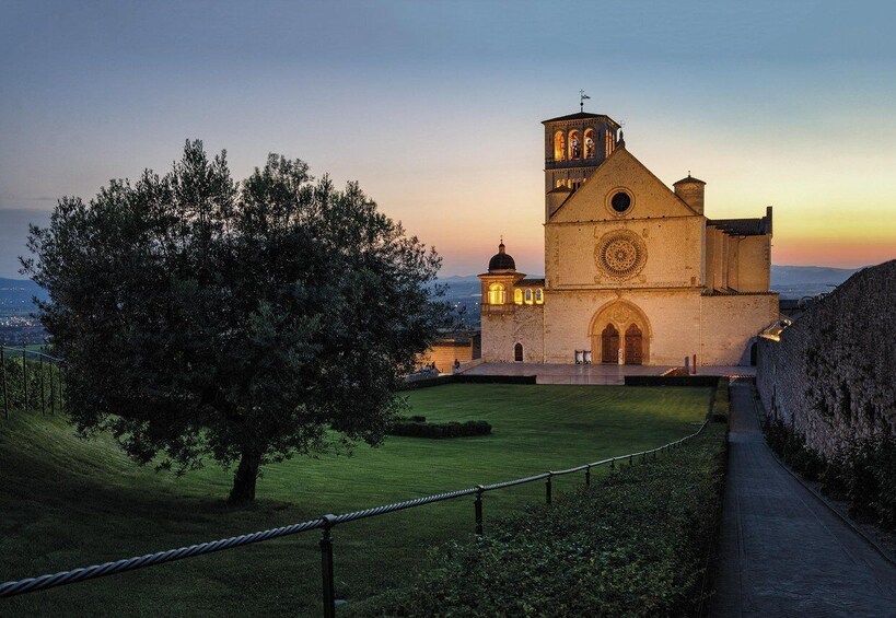 A historic church with a bell tower, surrounded by a well-maintained lawn and a stone wall. 1